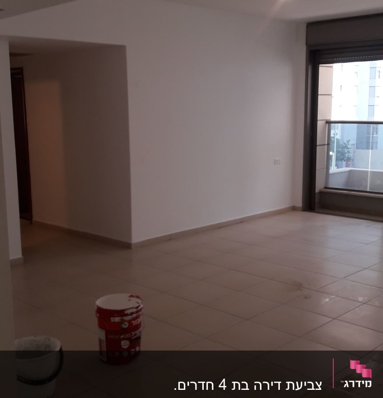 דלי צבע אדום ולבן על רצפה בחדר ריק